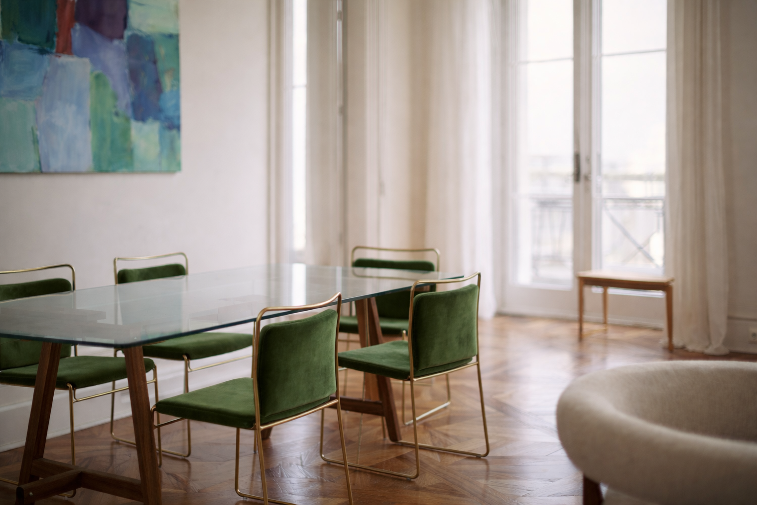 Dining room with a glass table and green chairs, large windows, and abstract art on the wall.