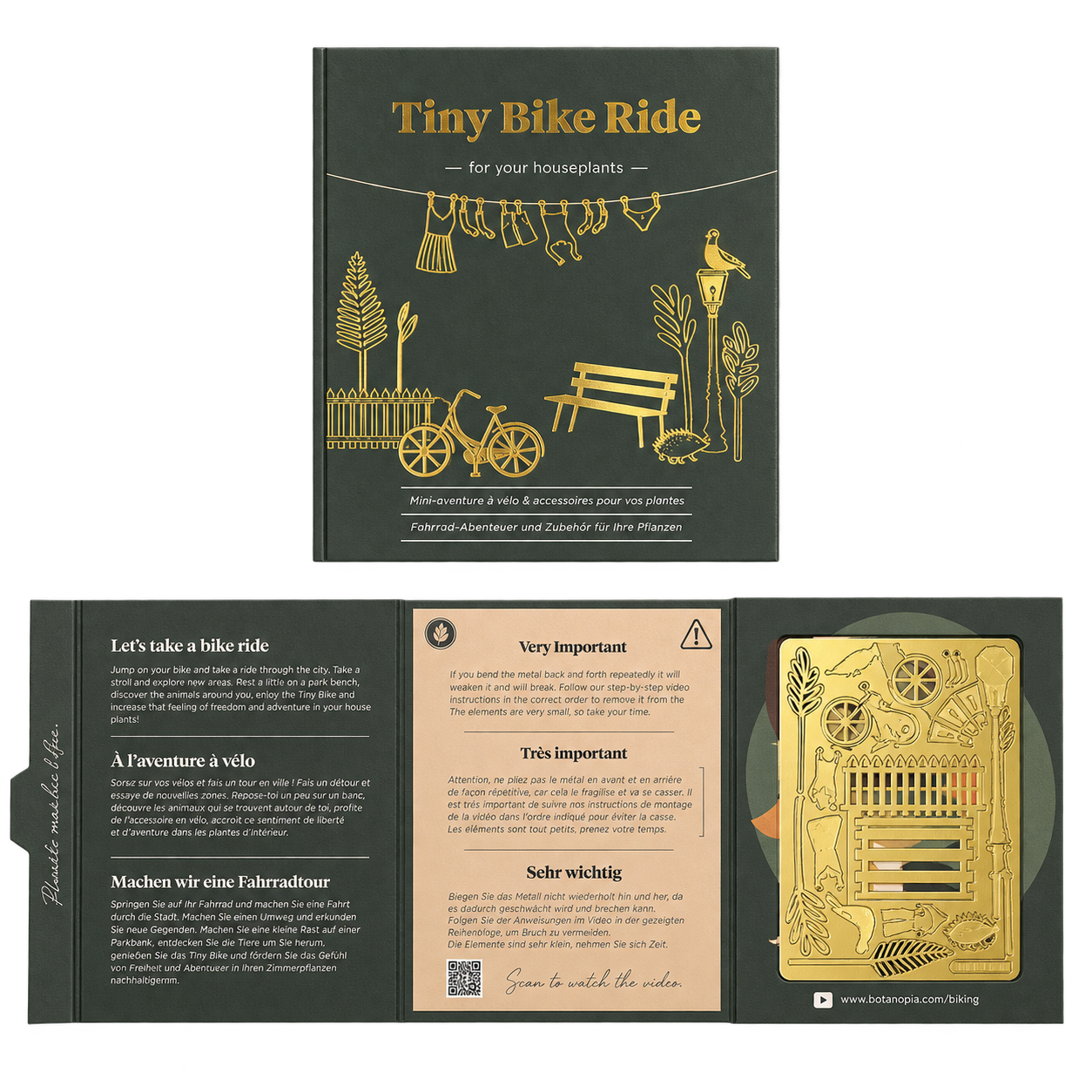 A boxed craft kit titled 'Tiny Bike Ride' shown open to reveal printed instructions, a small bicycle-themed card, and a gold-colored metal component inside a dark olive-green box.