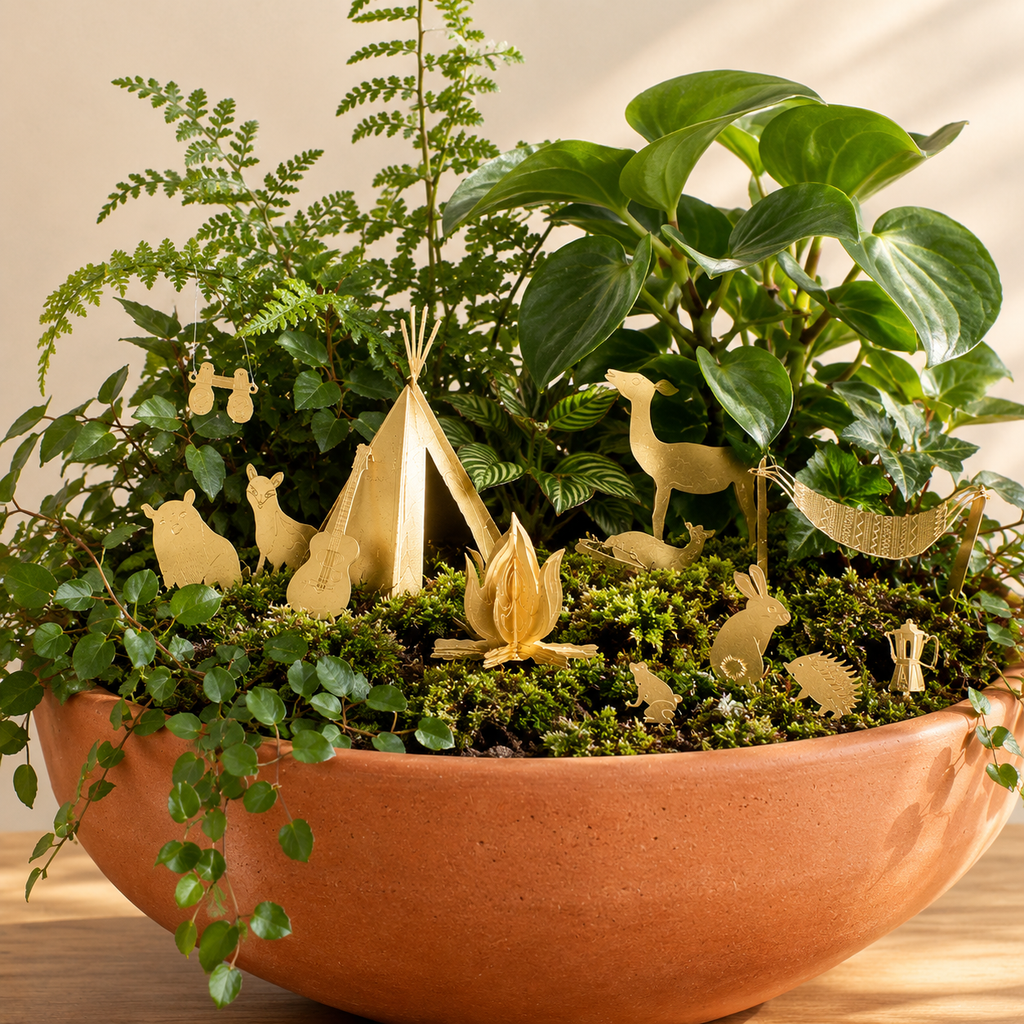 Camp decorations around a plant set i a terracotta bowl.